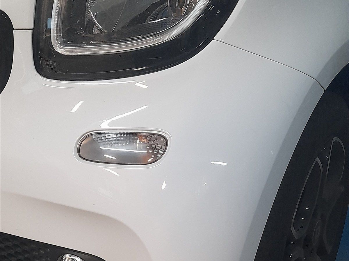 Frontpartie eines weißen Kleinwagens nach Smart-Repair, sauber und glänzend